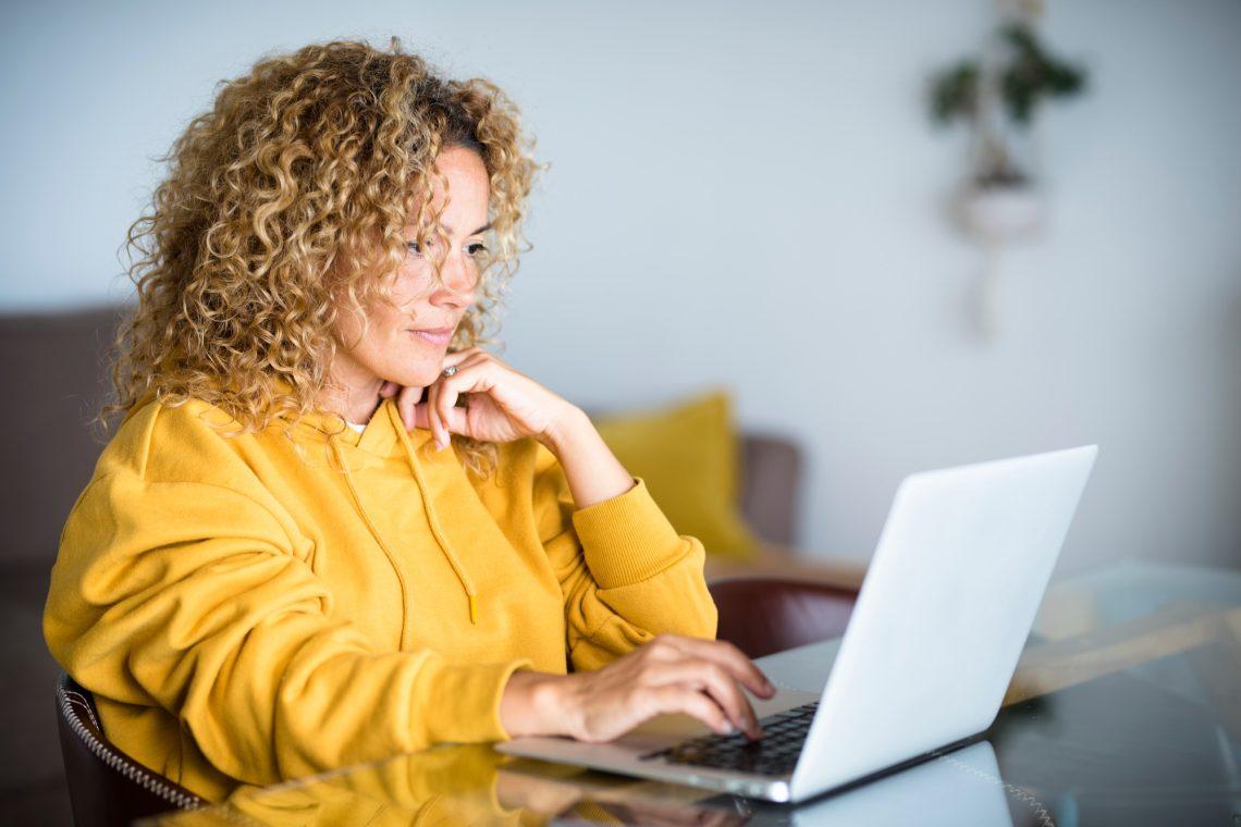 Beautiful middle age modern woman work at computer