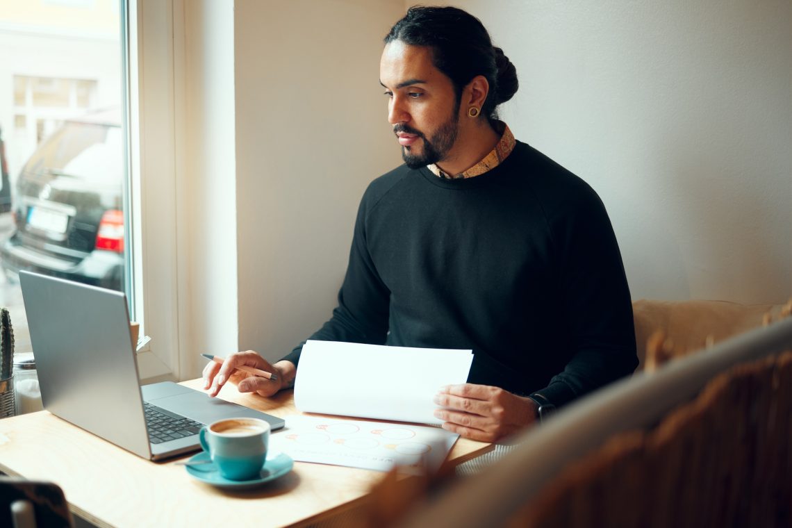 Startup, research or business man on laptop in coffee shop for strategy planning, life insurance or